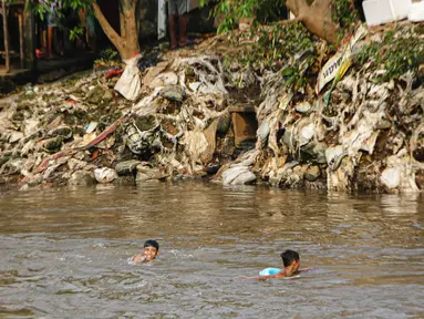 Anak-anak bermain di bantaran Kali Ciliwung, Jakarta, Selasa (27/6/2023). (Liputan6.com/Faizal Fanani)