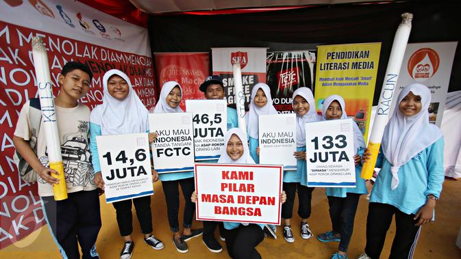 Siswa SMP dari perwakilan delapan sekolah di Jakarta dan Bandung memegang replika rokok dan poster saat mengikuti kegiatan bertajuk 'Sekolah Tanpa Asap Rokok (STAR): Menolak Diam' di Taman Menteng, Jakarta, Sabtu (21/11). (Liputan6.com/Immanuel Antonius)
