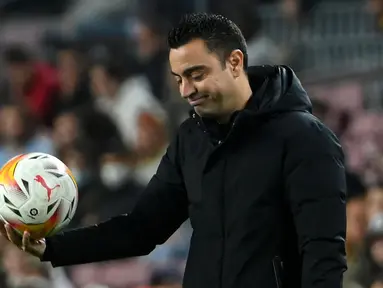 Ekspresi kekecewaan pelatih Xavi Hernandez terlihat jelas ketika Barcelona dikalahkan Cadiz dengan skor 0-1 pada laga pekan ke-32 Liga Spanyol 2021/2022 di Camp Nou, Selasa (19/04/2022) dini hari WIB. (AFP/Lluis Gene)