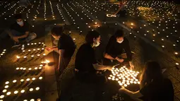 Warga menyalakan lilin pada peringatan 25 tahun pembunuhan Perdana Menteri Israel Yitzhak Rabin, di Rabin Square, Tel Aviv, Kamis (29/10/2020). Yitzhak Rabin ditembak ekstremis Yahudi, Yigal Amir usai melakukan pidato perdamaian Kings of Israel Square pada 4 November 1995. (AP Photo/Oded Balilty)