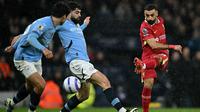 Winger Liverpool, Mohamed Salah (kanan), melepaskan tendangan keras melewati adangan bek Manchester City, Josko Gvardiol, saat kedua tim bertanding dalam lanjutan Liga Inggris 2024/2025 di Etihad Stadium, Minggu (23/2/2025) malam WIB. (Paul ELLIS / AFP)
