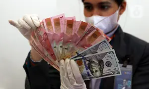 Karyawan menunjukkan uang rupiah dan dolar AS di Jakarta, Rabu (30/12/2020). Nilai tukar rupiah di pasar spot ditutup menguat 80 poin atau 0,57 persen ke level Rp 14.050 per dolar AS. (Liputan6.com/Johan Tallo)