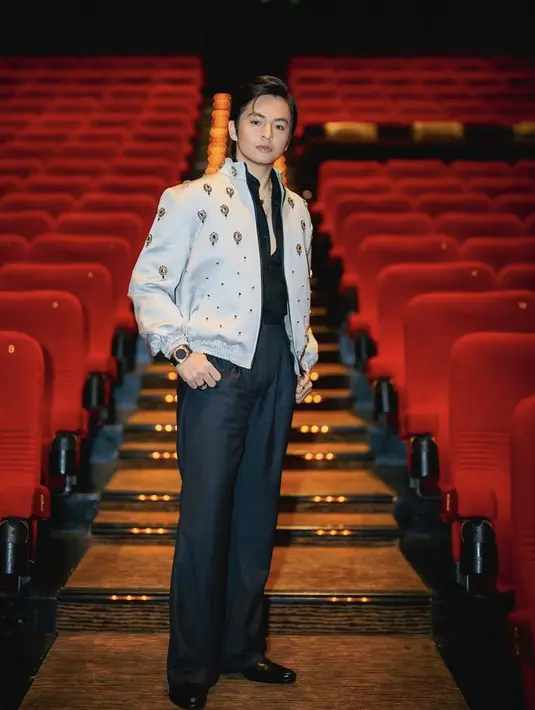 Sebagai pemeran utama, Angga tampil mengenakan outer jaket yang memiliki aksen payetan dari fashion designer Hartono Gan. Dipadukan dengan kemeja dan celana hitam. [Instagram/@angga]