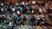 Warga muslim Iran berkumpul untuk berbuka puasa bersama di sebuah jalan di Teheran, 29 Mei 2018. Sebagian besar warga muslim Iran melaksanakan ibadah puasa di bulan Ramadan sesuai ajaran Islam melalui Nabi Muhammad. (AP Photo/Vahid Salemi)