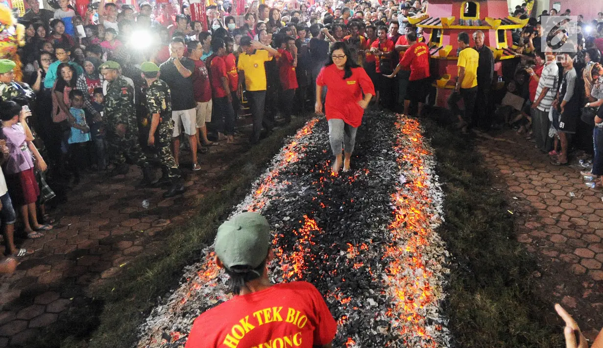 Warga melakukan atraksi Tahwe atau menginjak bara api di Hok Tek Bio Cibinong, Bogor, Sabtu (17/3). Tradisi injak bara tersebut dalam rangka rangkaian Sejit (ulang tahun) Kongco Ho Tek Tjeng Sin atau Dewa Bumi. (Merdeka.com/Arie Basuki)