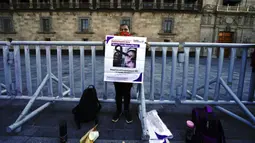 Maria de la Luz Flores memegang poster putrinya Guadalupe Morales Flores yang hilang pada 7 September 2020 dan ditemukan 29 Maret 2021 saat protes di luar Istana Nasional menuntut jawaban dari pemerintah tentang orang-orang hilang di Mexico City, Meksiko, 13 Desember 2021. (AP Photo/Marco Ugarte)