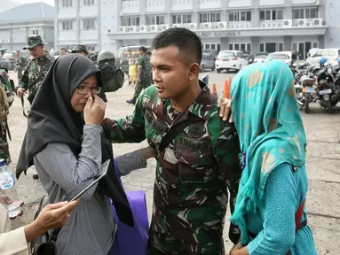 Salah satu anggota keluarga menangis saat seorang prajurit berpamitan sebelum menaiki KRI Teluk Ratai 509 di Dermaga Mako Kolinlamil, Jakarta, Rabu (27/1). 1300 prajurit diberangkatkan menjaga perbatasan darat RI-Malaysia. (Liputan6.com/Faizal Fanani)