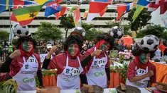 Para peserta yang mengenakan seragam tim sepak bola Portugal menyiapkan rujak uleg cingur, salad gurih tradisional khas Indonesia yang berisi moncong sapi dan sayuran, dalam Festival Rujak Uleg 2026 di Surabaya, Jawa Timur, Sabtu 9 Mei 2026. Pemerintah Kota Surabaya menggelar Festival Rujak Uleg 2026. (JUNI KRISWANTO/AFP)