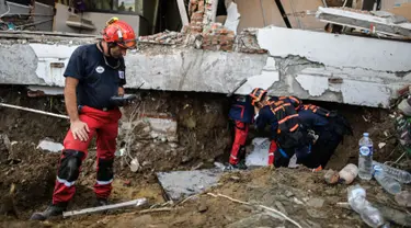 Seorang anggota dari Pemadam Kebakaran Darurat Internasional Prancis melihat suatu alat sebelum memasuki hotel Mercure yang rusak parah untuk operasi pencarian dan penyelamatan korban gempa dan tsunami di Palu, Sulteng (4/10). (AFP Photo/Mohd Rasfan)