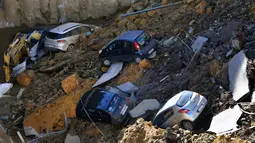 Sejumlah mobil terperosok ke dalam jalanan yang ambles di distrik Balduina, kawasan barat ibu kota Italia, Roma, Kamis (15/2). Pihak berwenang memerintahkan 22 keluarga di apartemen-apartemen dalam dua blok diungsikan. (AFP PHOTO / TIZIANA FABI)