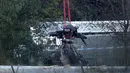 Crane mengevakuasi bangkai helikopter dari lokasi kecelakaan yang menewaskan pemilik Leicester City Vichai Srivaddhanaprabha di Leicester, Inggris, Kamis (1/11). Selain Vichai, 4 orang lainnya juga tewas dalam kecelakaan tersebut. (Aaron Chown/PA via AP)