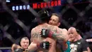 Conor McGregor memeluk Donald 'Cowboy' Cerrone setelah mengalahkannya pada pertarungan kelas welter UFC 246 di T-Mobile Arena, Las Vegas, Amerika Sertikat, Sabtu (18/1/2020). McGregor mengalahkan Cowboy pada detik ke-40. (Steve Marcus/Getty Images/AFP)