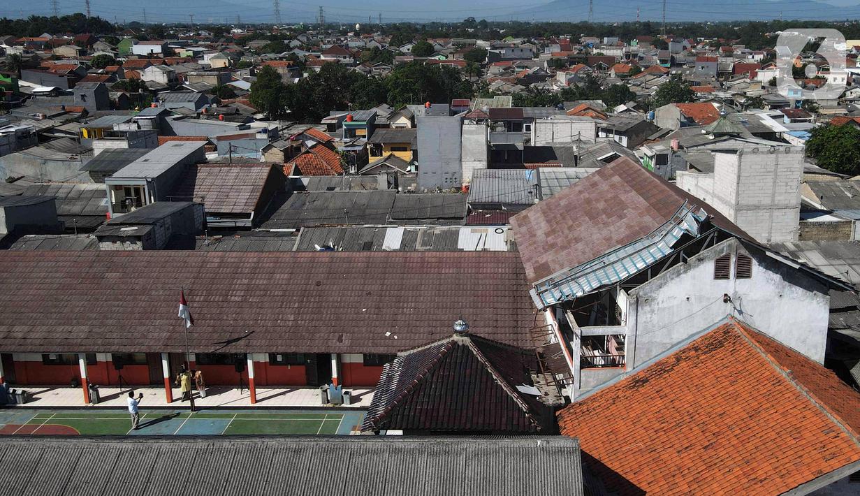 Foto udara ruang kelas yang atapnya ambruk di SDN Pancoranmas 3, Depok, Jawa Barat, Jumat (13/5/2022). Dua ruang kelas di SDN Pancoranmas 3 mengalami kerusakan pada bagian atap bangunan yang ambruk akibat hujan deras disertai angin kencang pada 19 April 2022. (Liputan6.com/Herman Zakharia)