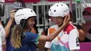 Skater Brasil Rayssa Leal (kiri) memberi selamat kepada skater Jepang Momiji Nishiya setelah memenangkan final street skateboarding putri Olimpiade Tokyo 2020 di Tokyo, Jepang, 26 Juli 2021. Momiji meraih medali emas Olimpiade saat berusia 13 tahun dan 330 hari. (AP Photo/Ben Curtis)