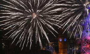 Kembang api memancar di sekitar The Elizabeth Tower, juga dikenal sebagai 'Big Ben' dan London Eye saat perayaan Tahun Baru di London, Inggris (1/1/2016). (AFP Photo / Justin Tallis)