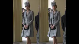 Kate Middleton terlihat tampil klasik dengan terusan abu-abu dan hiasan kepala berwarna senada, Inggris, (21/10/14). (AFP PHOTO/POOL/Carl Court)
