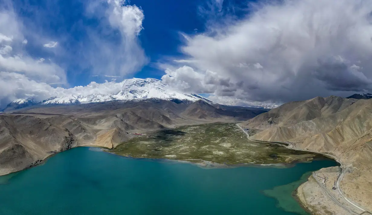Foto dari udara menunjukkan pemandangan Danau Karakul dan pegunungan bersalju di Dataran Tinggi Pamir, Daerah Otonom Uighur Xinjiang, China barat laut, 16 Juni 2020. (Xinhua/Hu Huhu)