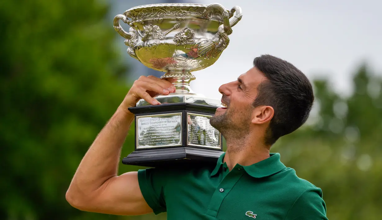 Petenis Serbia Novak Djokovic berpose dengan Norman Brookes Challenge Cup usai menjuarai Australian Open 2023 di Taman Government House, Melbourne, Australia, 30 Januari 2023. Upaya Djokovic untuk memenangkan gelar Australia Open tahun ini tidak mudah. (AP Photo/Ng Han Guan)