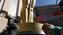 Seniman membersihkan tulisan patung Oscar di luar Teater Dolby saat persiapan jelang 88 Academy Awards di Hollywood, California (24/2). Piala Oscar merupakan penghargaan film Amerika untuk menghargai suatu karya industri film. (REUTERS/Mario Anzuoni)