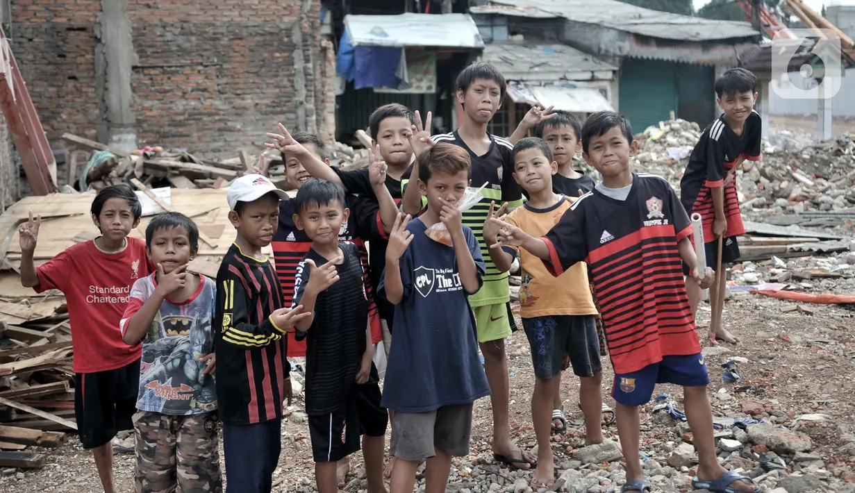 Anak-anak berpose di lokasi pembebasan lahan proyek Tol Becakayu, Cipinang Besar Utara, Jakarta, Senin (30/12/2019). Tercatat sedikitnya 900 rumah warga di 3 RW, yakni RW 001, 002, dan 003 Kelurahan Cipinang Besar Utara terkena gusuran akibat proyek Tol Becakayu. (merdeka.com/Iqbal S. Nugroho)