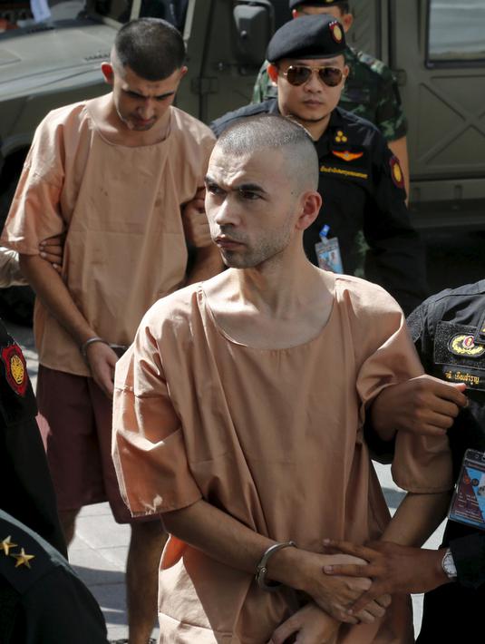 Petugas menggiring tersangka pemboman Yusufu Mieraili dan Bilal Mohammed saat meninggalkan Pengadilan militer (24/11). Pengadilan Thailand telah mendakwa dua orang yang dituduh melakukan serangan bom di Bangkok. (REUTERS /Chaiwat Subprasom)
