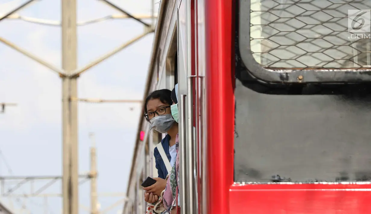 Penumpang berada di rel Kereta rel listrik (KRL) Jabodetabek rute Depok-Jatinegara yang mengalami anjlok di Stasiun Jatinegara, Jakarta Timur, Senin (30/10). Peristiwa itu berdampak keterlambatan perjalanan kereta lainnya. (Liputan6.com/Immanuel Antonius)