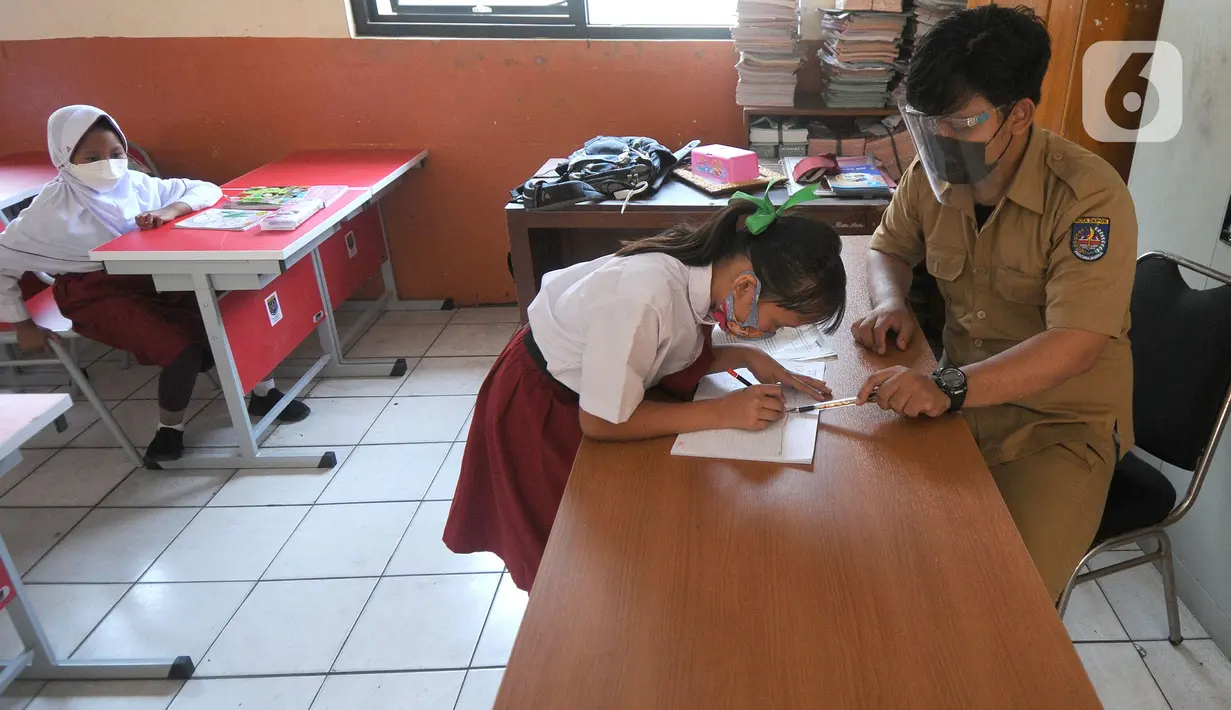 Guru mengawasi siswa saat simulasi Pembelajaran Tatap Muka Terbatas (PTMT) di SDN 03 Cinere, depok, Jawa Barat, Selasa (28/09/2021). Pemkot  Depok hari ini menyelenggarakan simulasi Pembelajaran Tatap Muka Terbatas (PTMT) dari jenjang TK sampai SMP Negeri. (merdeka.com/Arie Basuki)