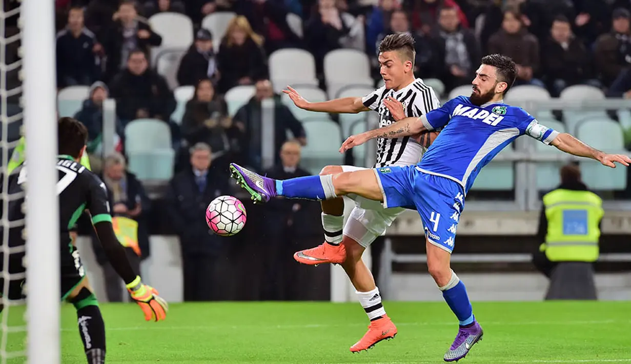 Striker Juventus, Paulo Dybala , berebut bola dengan gelandang Sassuolo, Francesco Magnelli. Gol kemenangan Juve yang dicetak Paulo Dybala tercipta pada menit ke-39 melalui umpan Juan Cuadrado. (AFP/Giuseppe Cacace)