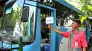 Petugas feeder bus Transjakarta sedang menunggu calon penumpang di seberang Stasiun Tebet , Jakarta, Kamis (7/4). Pengoperasian ini bagian dari antisipasi penumpukan penumpang saat perlintasan KRL Tebet ditutup. (Liputan6.com/Yoppy Renato)