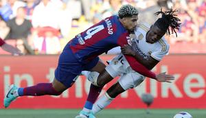 Bek Barcelona, Ronald Araujo melanggara gelandang Real Madrid, Eduardo Camavinga dalam laga El Clasico di La Liga 2023/2024. (AFP/Lluis Gene)
