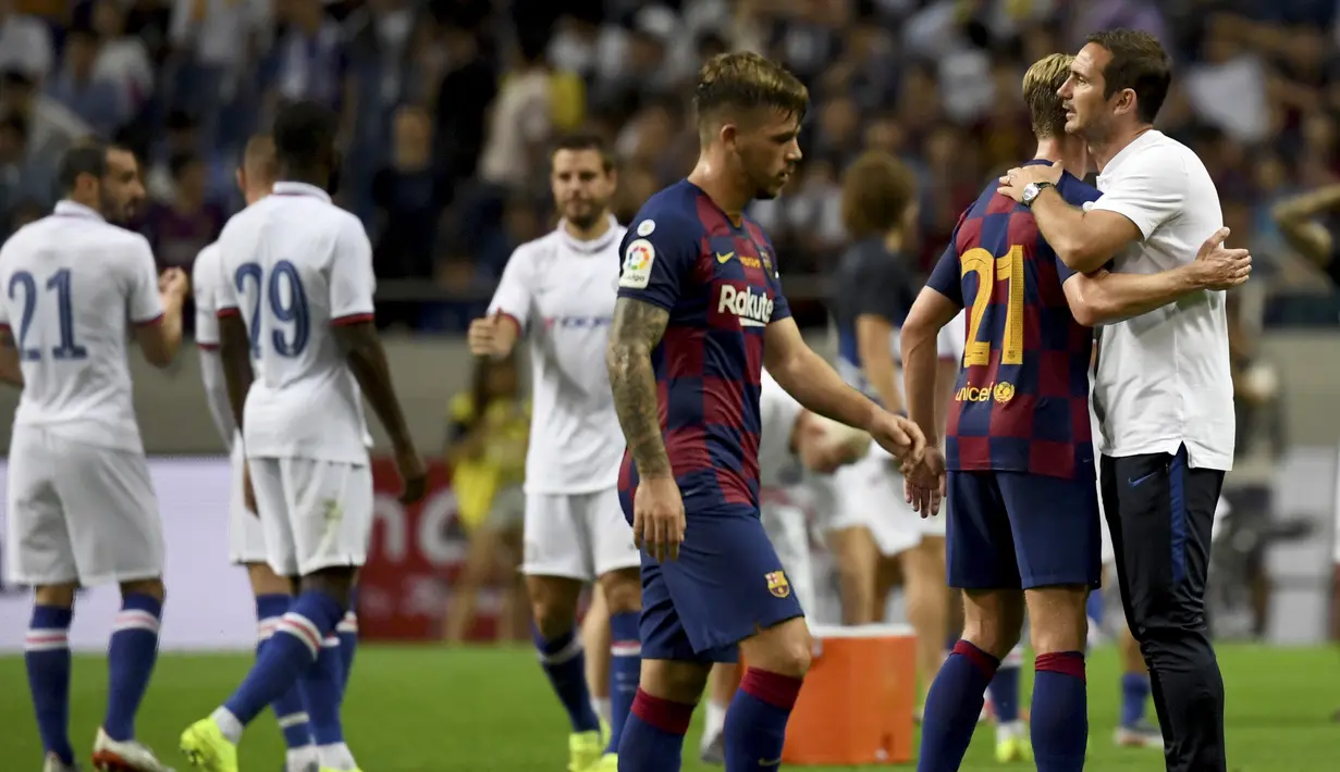 Pelatih Chelsea Frank Lampard  memeluk gelandang Barcelona, Frankie de Jong usai pertandingan melawan Barcelona pada laga perdana pramusim di Saitama Stadium 2002, Saitama (23/7/2019). Chelsea menang tipis atas Barcelona 2-1. (AFP Photo/Toshifumi Kitamura)