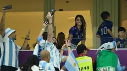Istri penyerang Argentina Lionel Messi, Antonela Roccuzzo, menyapa suporter jelang laga semifinal Piala Dunia Qatar 2022 antara Argentina dan Kroasia di Lusail Stadium di Lusail, Doha, Rabu (14/12/2022). Argentina menang atas Kroasia 3-0. (AFP/Juan Mabromata)