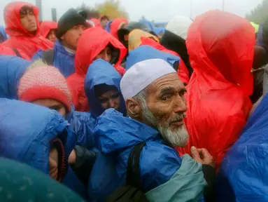 Para pengungsi saat menunggu menyeberang perbatasan dari Slovenia menuju Trnovec, Kroasia, Senin (19/10). Ribuan orang terjebak cuaca dingin di desa perbatasan Serbia Berkasovo setelah Kroasia membendung para pendatang. (REUTERS/Antonio Bronic)