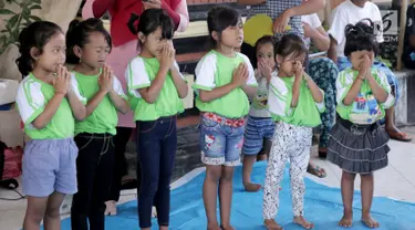 Anak-anak TK berdoa sebelum mengikuti sekolah di kamp pengungsian Gor Swace Pura, Klungkung, Bali, Kamis (28/09). Kegiatan tersebut bertujuan menghilangkan rasa trauma serta sebagai sarana bermain anak korban bencana alam. (Liputan6.com/Gempur M Surya)