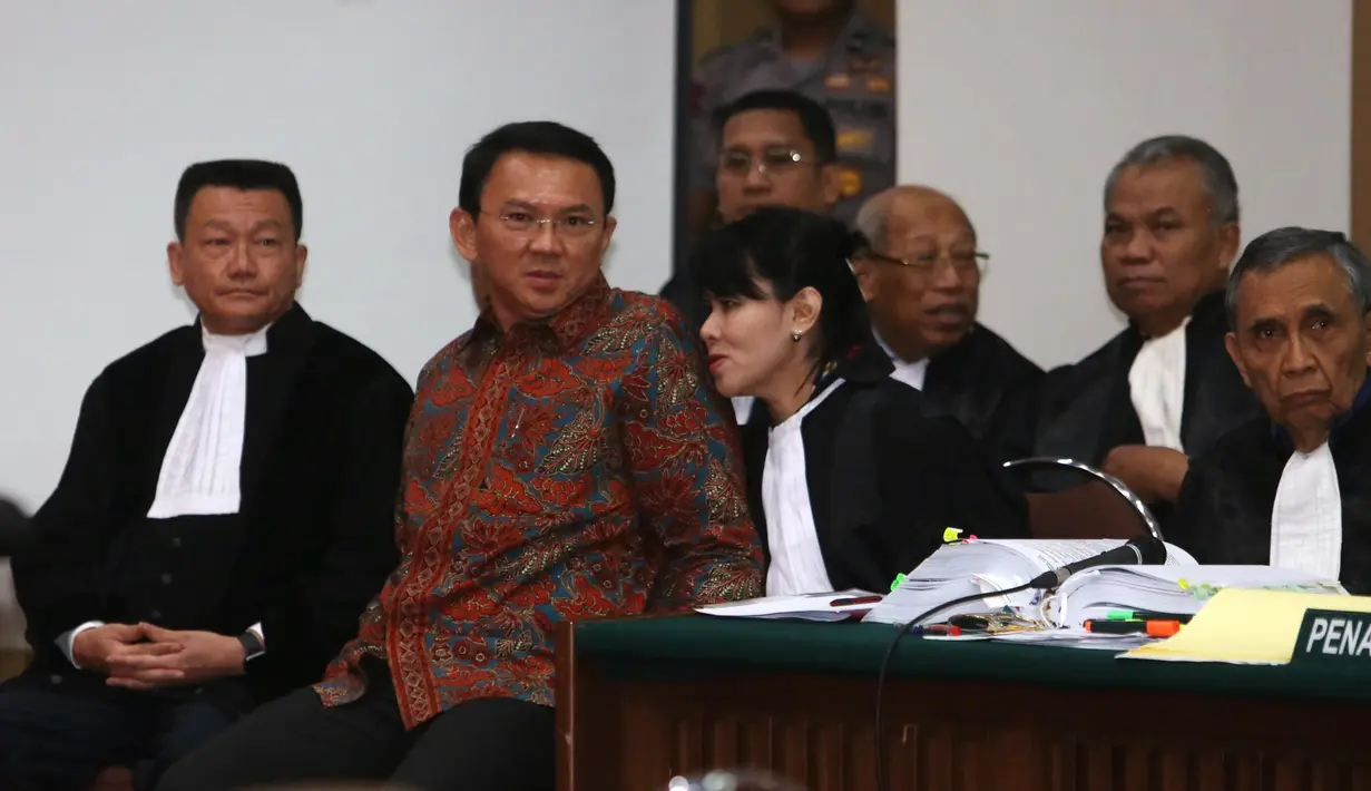 Basuki Tjahaja Purnama (Ahok) berbincang dengan penasehat hukumnya disela sidang lanjutan di Auditorium Kementan, Jakarta, Selasa (31/1). Sidang kedelapan ini menghadirkan lima saksi dari JPU, salah satunya Ketua MUI. (Liputan6.com/Seto Wardhana/Pool)