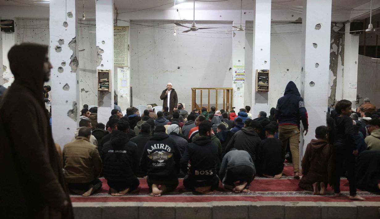 Sebagaimana diketahui, malam-malam ganjil di akhir Ramadan merupakan momen terbaik bagi umat Muslim untuk memperbanyak ibadah sekaligus meningkatkan ketakwaan sebagai seorang hamba. Tampak dalam foto, umat Muslim melaksanakan salat malam di Masjid Mahaba yang rusak selama perang Israel-Hamas di Khan Yunis, Jalur Gaza selatan pada Senin 16 Maret 2026. (Bashar Taleb/AFP)
