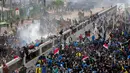 Mahasiswa berlarian saat polisi menembakkan gas air mata dalam demonstrasi menolak pengesahan RUU KUHP dan revisi UU KPK di depan Gedung DPR, Jakarta, Selasa (24/9/2019). Polisi menyemprotkan air ke arah mahasiswa karena menolak untuk dibubarkan. (Liputan6.com/Faizal Fanani)