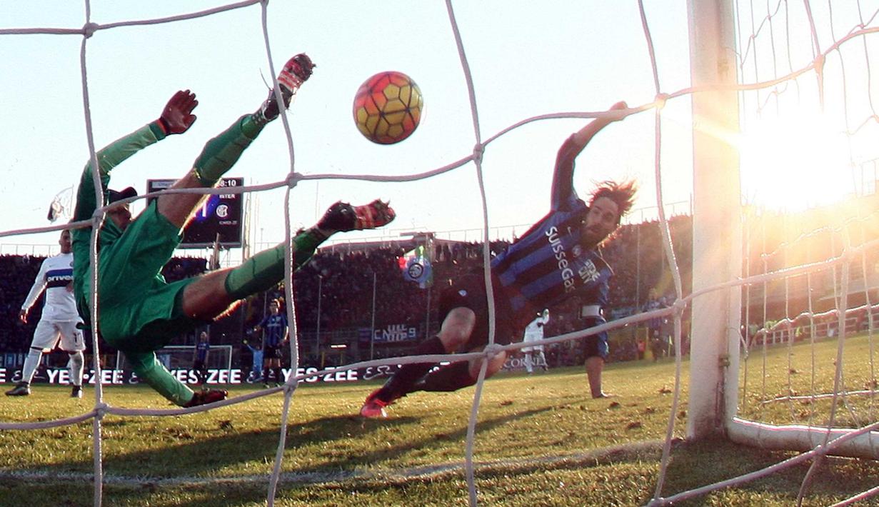 Kiper Inter Milan, Samir Handanovic (kiri)  menghalau bola sepakan pemain Atalanta,  Luca Cigarini pada lanjutan Liga Italia Serie A di Stadion Atleti Azzurri, Bergamo, Sabtu (16/1/2016).  (EPA/Paolo Magni)