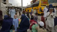 Keluarga Afghanistan menunggu naik bus untuk berangkat ke tanah air mereka, di Karachi, Pakistan, Jumat, 6 Oktober 2023. (AP Photo/Fareed Khan)