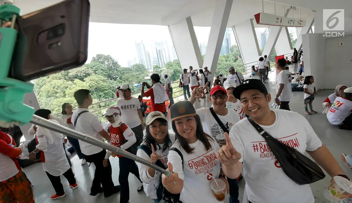 Pendukung capres dan cawapres Joko Widodo (Jokowi)-Ma'ruf Amin berswafoto pada kampanye akbar di Stadion Utama GBK, Senayan, Jakarta, Sabtu (13/15). Kampanye diisi dengan konser musik dari ratusan selebritas bertajuk Konser Putih Bersatu. (Liputan6.com/Herman Zakharia)