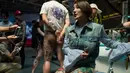 Seorang wanita berpose memperlihatkan tato dikakinya saat acara Langfang Internasional Tattoo di Hebei, China (29/5/2016). (AFP PHOTO / FRED Dufour)