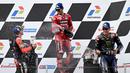 Pembalap Ducati Lenovo Team, Francesco Bagnaia (tengah), bersama pembalap Aprilia Racing, Maverick Vinales (kiri) dan pembalap Monster Energy Yamaha, Fabio Quartararo, melakukan selebrasi setelah menjadi juara di MotoGP Mandalika 2023, Minggu (15/10/2023) siang WIB. (AFP/Sonny Tumbelaka)