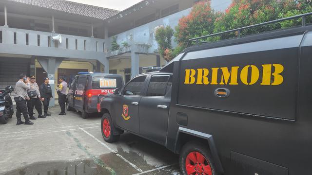 Anggota Brimob melakukan pengecekan terkait adanya teror bom di salah satu sekolah wilayah Depok (Liputan6.com/Dicky Agung Prihanto)