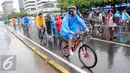 Sejumlah warga mengenakan jas hujan saat mengikuti kegiatan Car Free Day, Jakarta, Minggu (24/1/2016). Meski hujan mengguyur Ibu Kota sejak semalam, kegiatan CFD pagi di kawasan Bundaran Hotel Indonesia masih tetap ramai. (Liputan6.com/Helmi Affandi)