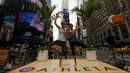 Dua wanita melakukan gerakan yoga di tengah jalan saat perayaan Summer Solstice di Hari Yoga Internasional di Times Square, New York, Minggu (21/6/2015). (REUTERS/Eduardo Munoz)