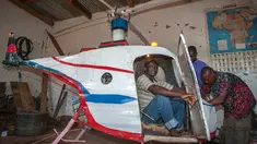 Felix Kambwiri duduk di kokpit helikopter buatannya di garasi rumahnya di Desa Gobede, Malawi, 19 Februari 2016. Helikopter yang dikerjakan sejak empat bulan lalu itu dibuat dari rongsokan besi tua dan fiberglass. (Amos Gumulira/AFP)