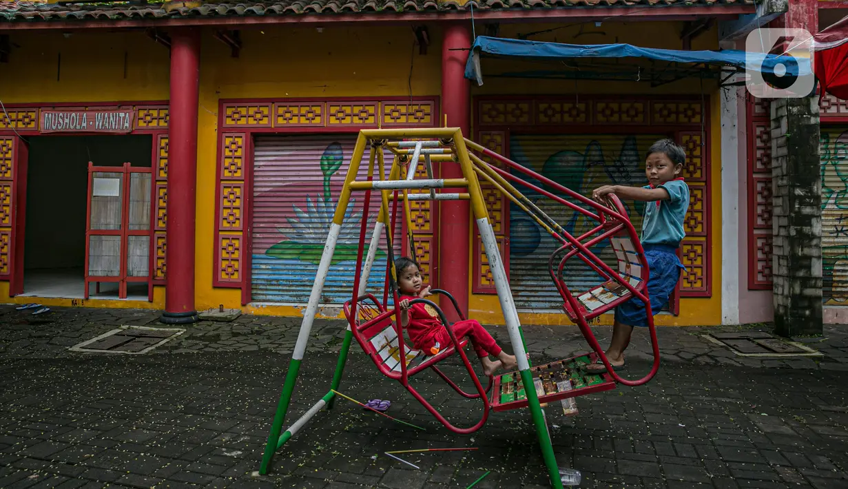 Anak-anak bermain di depan kios-yang tutup dan tak terawat di Kampung Cina, Kota Wisata, Jawa Barat, Minggu (14/2/2021). Dari 216 kios, tinggal puluhan kios yang masih bertahan. (Liputan6.com/Faizal Fanani)