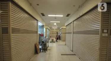 Pengunjung melintasi toko ritel yang tutup di salah satu pusat perbelanjaan kawasan Glodok, Jakarta, Senin (7/6/2021). Data Aprindo mencatat, sepanjang Maret 2020 hingga April 2021 sebanyak 1.250-1.300 toko ritel di Indonesia terpaksa tutup. (merdeka.com/Iqbal S. Nugroho)