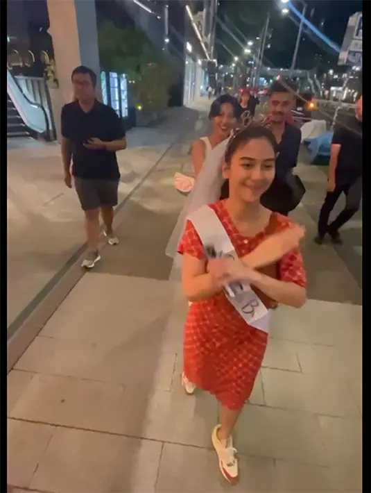 Potret bahagia Adinda saat jalan-jalan keliling Tokyo bersama para sahabatnya. Mengenakan daster merah dengan selempang putih bertuliskan "Bride to Be". Melengkapi penampilannya dengan veil pengantin dan juga mahkota kecil di kepala. [Instagram/fitaanggriani]