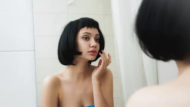 Seorang perempuan berambut pendek melakukan eksfoliasi bibir di kamar mandi (Foto Dok: Freepik/mnelen)